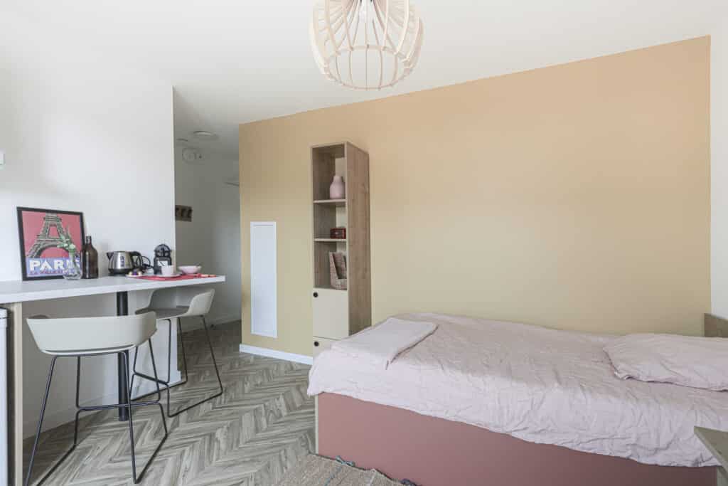 Vue d’ensemble d’un logement étudiant avec espace nuit, kitchenette et mobilier sur mesure réalisé par Structa dans la résidence Studéa Nice Vauban